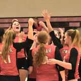 Volleyball players cheering in a gym